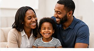 A smiling family — mother, father and young child — sitting together at home